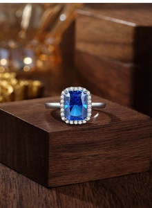 Macro shot of rectangular cushion-cut blue sapphire ring in halo silver setting