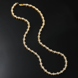 Collier tennis hip hop doré avec diamants étincelants sur une surface noire réfléchissante