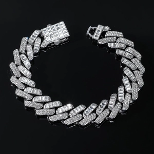 Gros plan sur bracelet cubain argenté serti de diamants et fermoir carré sur miroir noir
