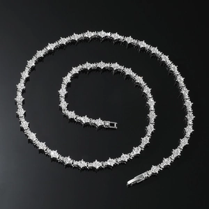 Vue macro d'un collier tennis hip hop argenté avec maillons floraux sertis de diamants
