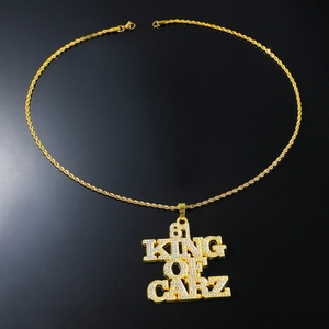 Dettaglio del ciondolo dorato 81 KING OF CARZ con strass su una catena a corda intrecciata
