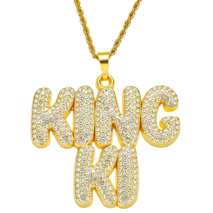 Gros plan du pendentif lettre KING KI plaqué or serti de strass étincelants