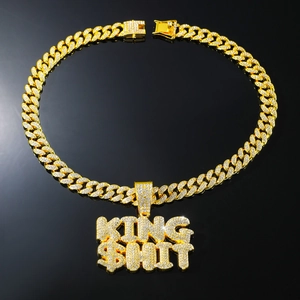 Close-up of gold Cuban chain necklace with iced-out KING SHIT letter pendant hip-hop style