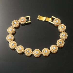 Gold hip hop bracelet featuring diamond-encrusted flower links on black reflective background