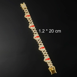 Detail of 1.2cm wide gold Cuban chain bracelet with iced out rhinestones and red heart charms