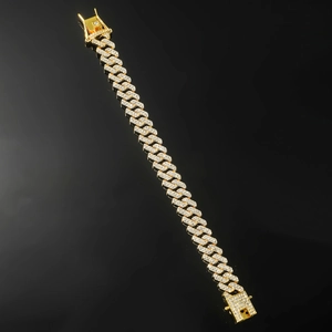 Vista macro del bracciale hip hop dorato con zirconi scintillanti su specchio nero