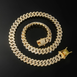 Detailed close-up of iced-out gold Cuban chain and bracelet set with box clasp