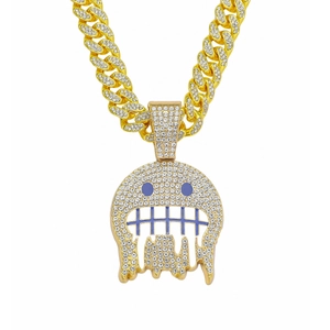 Dettaglio del ciondolo emoji mostro con zirconi, smalto blu e catena cubana placcata oro