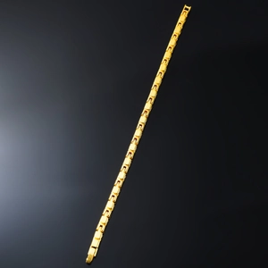 Close-up of polished gold-tone watch-band link bracelet with mirror finish and reflection