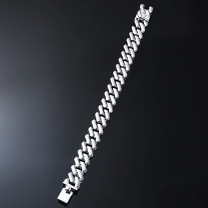 Detail of silver cuban link bracelet showing flat polished chain and square safety clasp