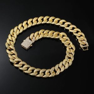 Gros plan d'une chaîne cubaine de 16 mm dorée avec texture maille et fermoir serti de strass