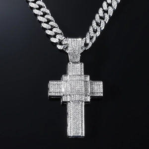 Détail macro du pendentif croix hip-hop argenté avec cristaux sur chaîne cubaine