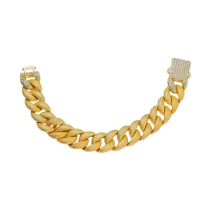 Detail van gouden Cubaanse schakelarmband met textuur en pavé gezette strass sluiting