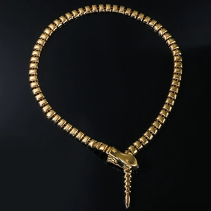 Détail d'un collier serpent doré avec des maillons métalliques rectangulaires articulés