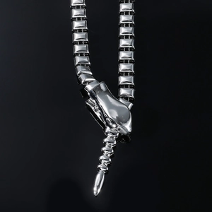 Gros plan sur le collier serpent argenté flexible avec tête et queue sur miroir noir