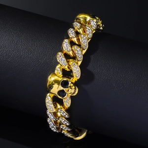 Vue macro du bracelet à mailles cubaines dorées avec crânes et zircons scintillants