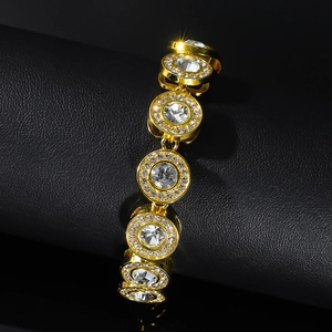 Detailed close-up of golden iced-out hip hop bracelet with large round crystals on black leather