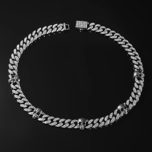 Collier à maillons cubains argentés avec crânes glacés sur fond noir réfléchissant