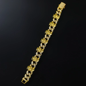 Macro shot of gold Cuban link bracelet with skull charms and white zircon stones