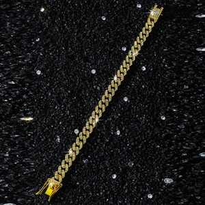 Detailed macro view of 9mm gold Cuban link chain with diamonds on dark stones