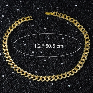 Macro shot of 12mm gold heart Cuban chain link necklace against black crystal background