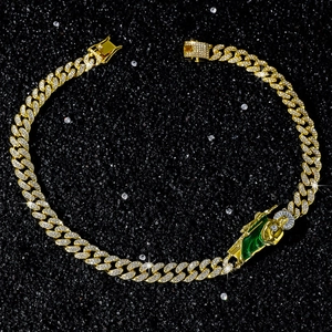 Detalle de cadena cubana dorada 12mm con colgante de San Judas en esmalte verde