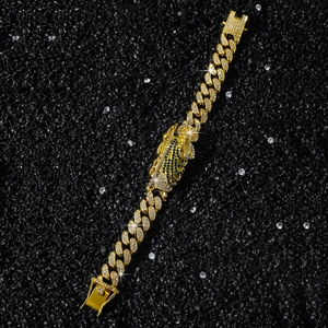 Macro detail of gold Cuban chain bracelet featuring diamond encrusted Saint Jude charm