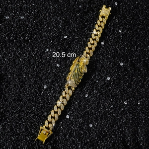 Detail of 20.5cm gold Cuban chain bracelet with St. Jude green stone and iced-out diamonds
