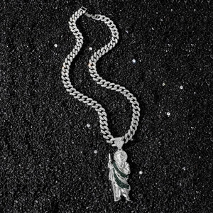 Hip hop St. Jude pendant with green zircons on silver Cuban chain over black stone