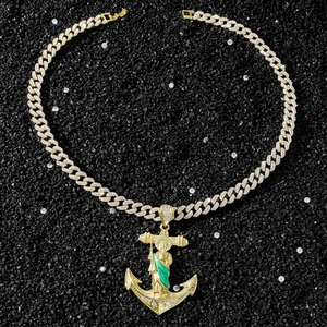 Vue détaillée du pendentif ancre Saint Jude doré avec cristaux sur pierres noires