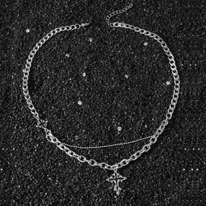 Men's double-layered silver cross necklace with curb chain on black stone background