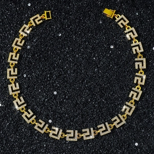 Macro shot of gold-plated hip hop chain link featuring iced-out Greek Key pattern