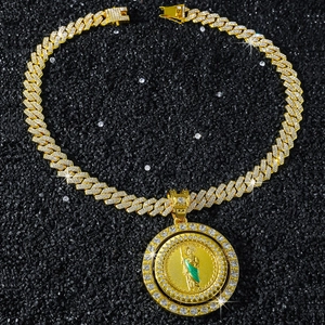 Détail du pendentif Saint Jude avec émail vert et strass blancs sur une chaîne dorée