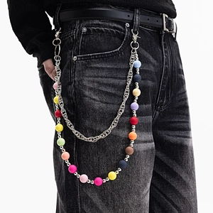 Détail d'une chaîne de pantalon multicouche colorée avec maillons métal et perles mates