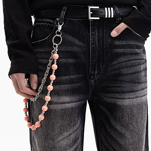 Chaîne de pantalon chic à perles colorées et maillons argentés sur un jean