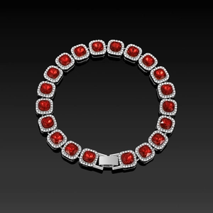 Macro shot of square cut ruby heart stone and silver pavé link bracelet on black