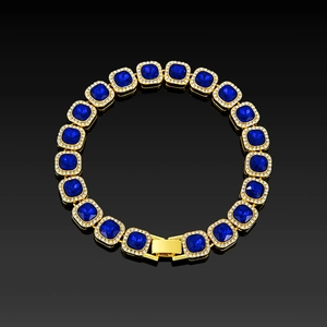 Close-up of golden chain featuring square blue stones with micro-pave halo crystals