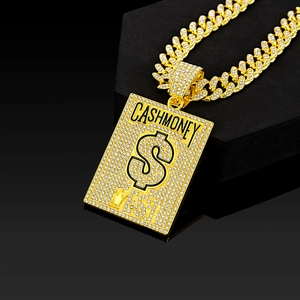 Macro shot of gold-plated iced-out Cuban chain and CASHMONEY dollar sign pendant