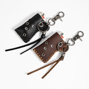 Close-up of black and brown cowhide leather lighter cases with metal carabiners