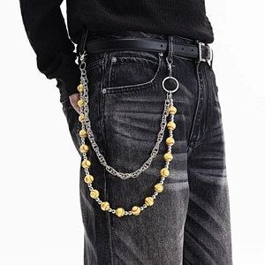 Détail d'une chaîne de pantalon hip-hop avec perles de baseball jaunes et maillons argent