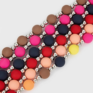 Détail de perles mates colorées et de sphères métalliques sur une chaîne de pantalon