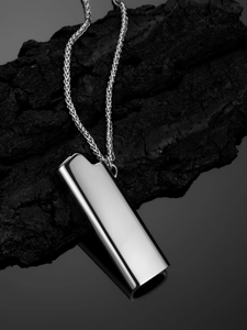 Polished silver lighter pendant necklace displayed on dark charred wood background