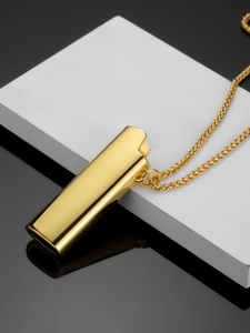 Macro shot of polished gold lighter pendant necklace with elegant wheat chain details