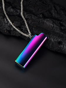 Macro detail of rainbow plated lighter case pendant on textured black coal background