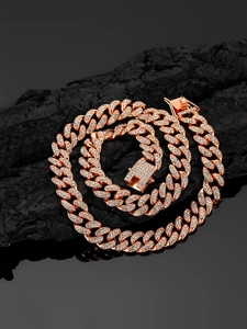 Primer plano de cadena cubana de oro rosa con diamantes sobre piedra negra mate