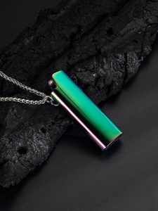 Macro view of gradient colored lighter pendant with silver chain on charcoal texture