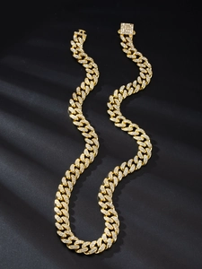 Dettaglio catena cubana oro 13mm con pavé di zirconi bianchi su uno sfondo scuro