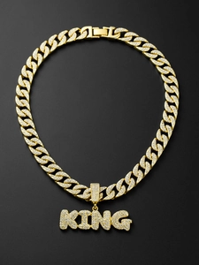 Close-up of iced out gold Cuban link chain with KING letter pendant and crystals