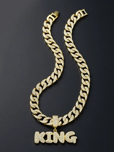 Detailed macro view of gold plated Cuban link chain with iced out KING letter pendant