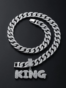 Detail of iced out Cuban link chain with sparkling KING letter pendant in silver finish